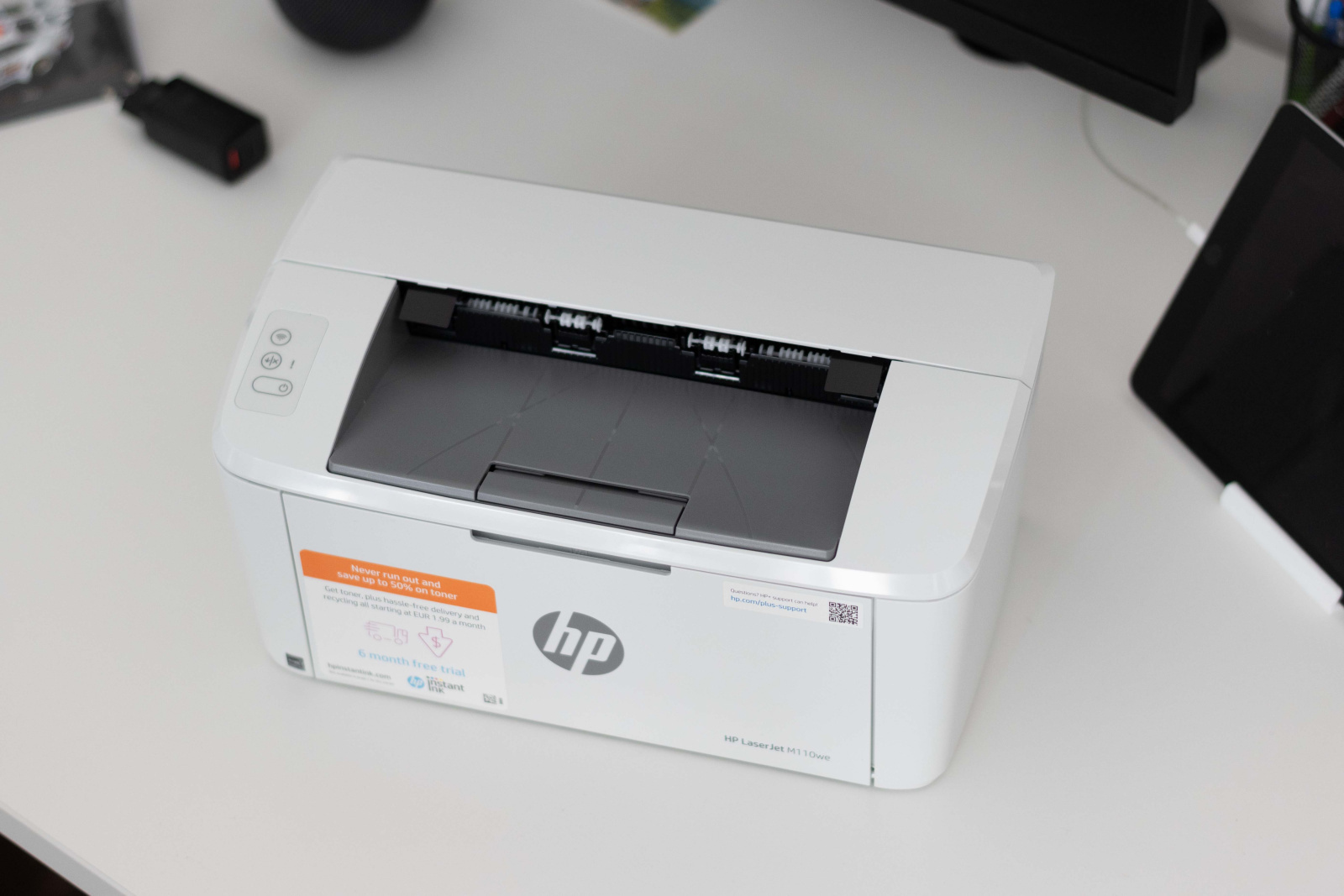 Tlačiareň HP LaserJet M110we zhora na kancelárskom stole.